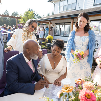 Bride and groom signing marriage papers at their intimate farm wedding.