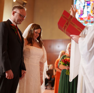 Bride and groom stand before officiant during Bastyr Chapel wedding ceremony.