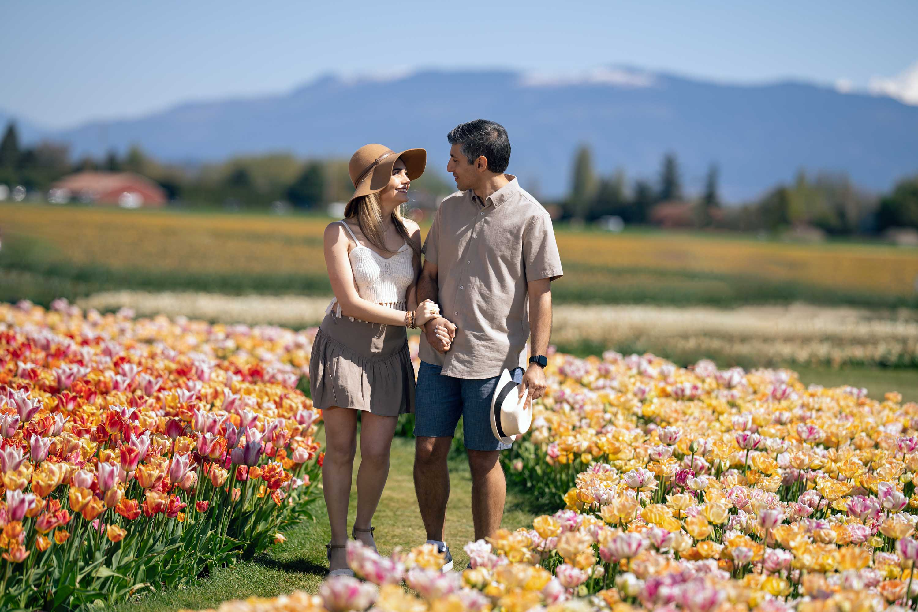 Happy couple walking hand-in-hand through vibrant tulip fields, tulip festival 2026.