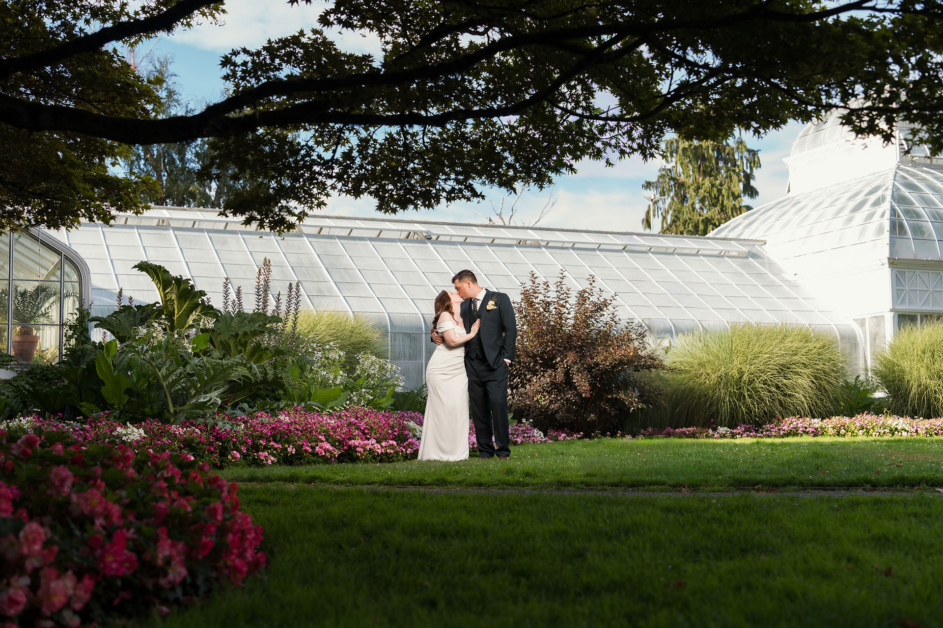 Wedding couple kissing at Volunteer Park Conservatory in Seattle.