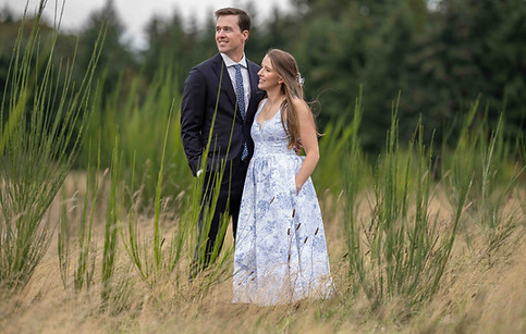 Engaged couple standing in tall grass field, PNW wedding photographer.