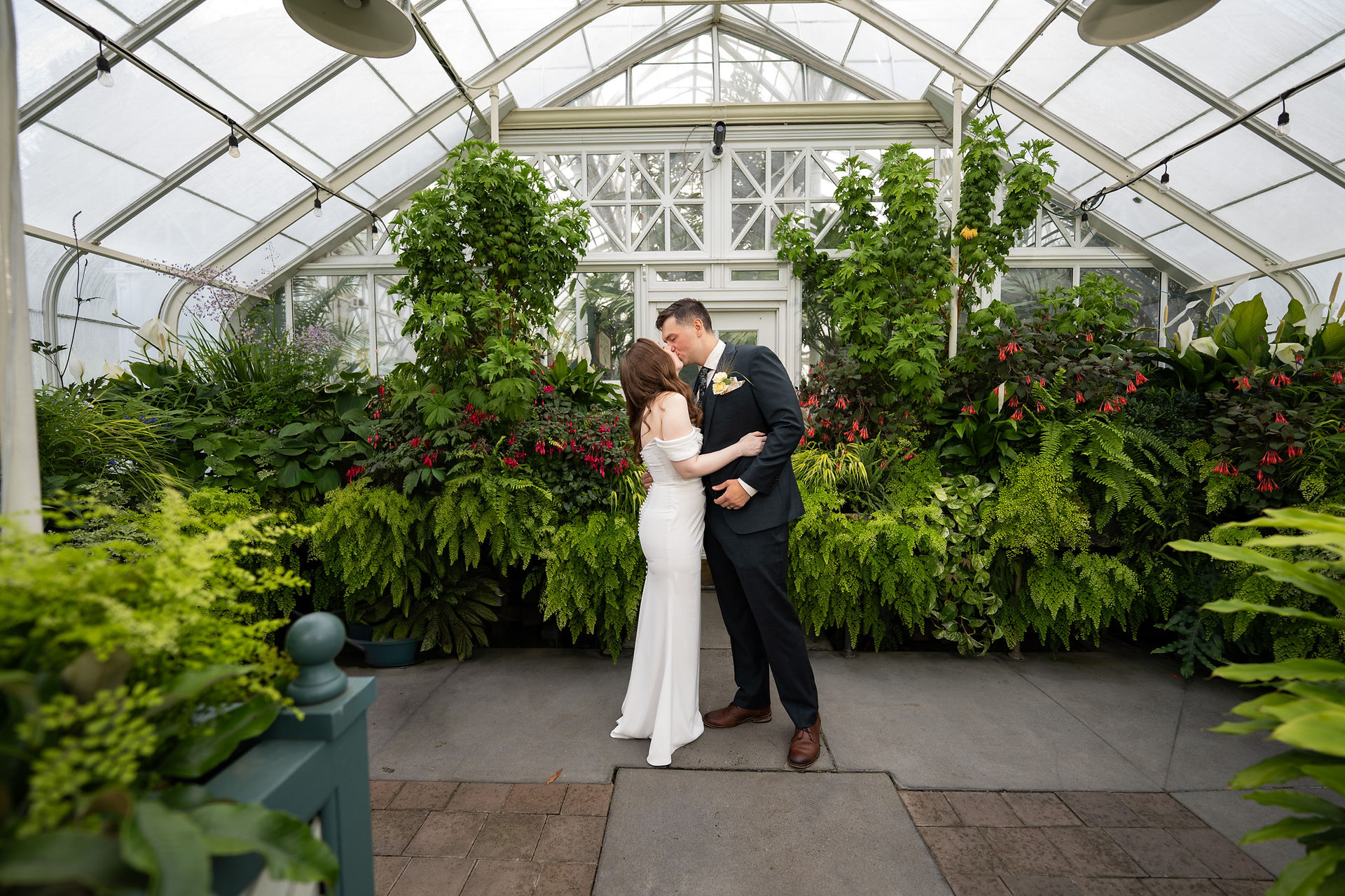 Wedding couple kissing at Volunteer Park Conservatory in Seattle.