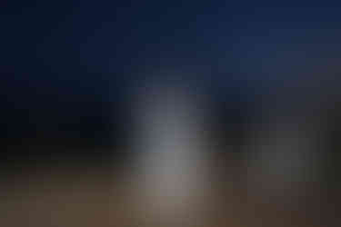 Newlywed couple shares their first dance outdoors at night.