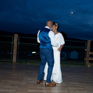 Couple dancing at night under a full moon, celebrating their wedding.
