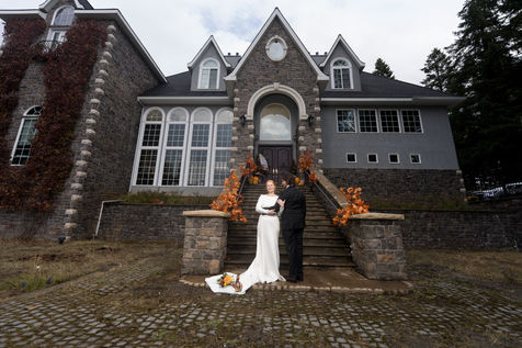Bride and groom exchanging vows on stone stairs at fall decorated house.