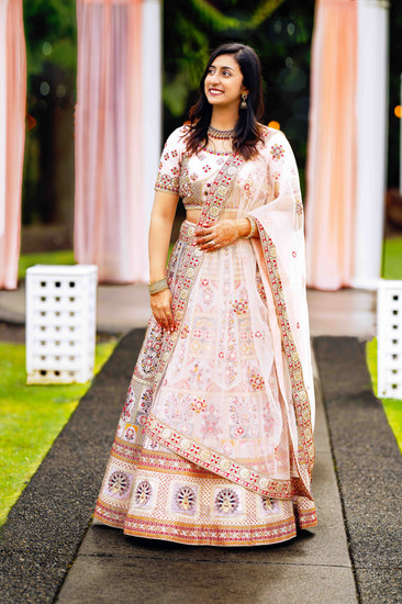 Smiling bride in beautiful white and pink wedding lehenga