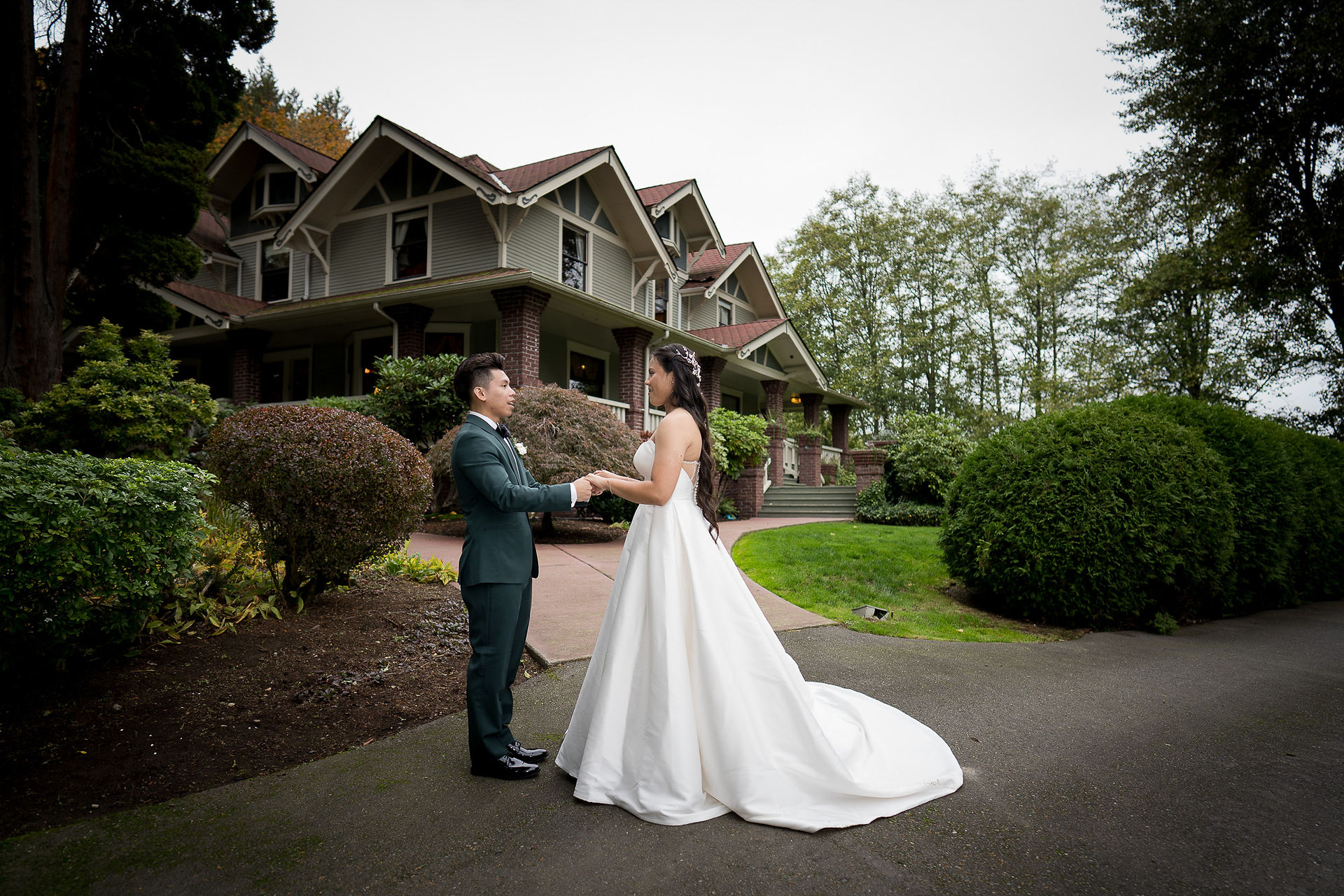 Elegant wedding couple holding hands outside the Sanders Estate building.