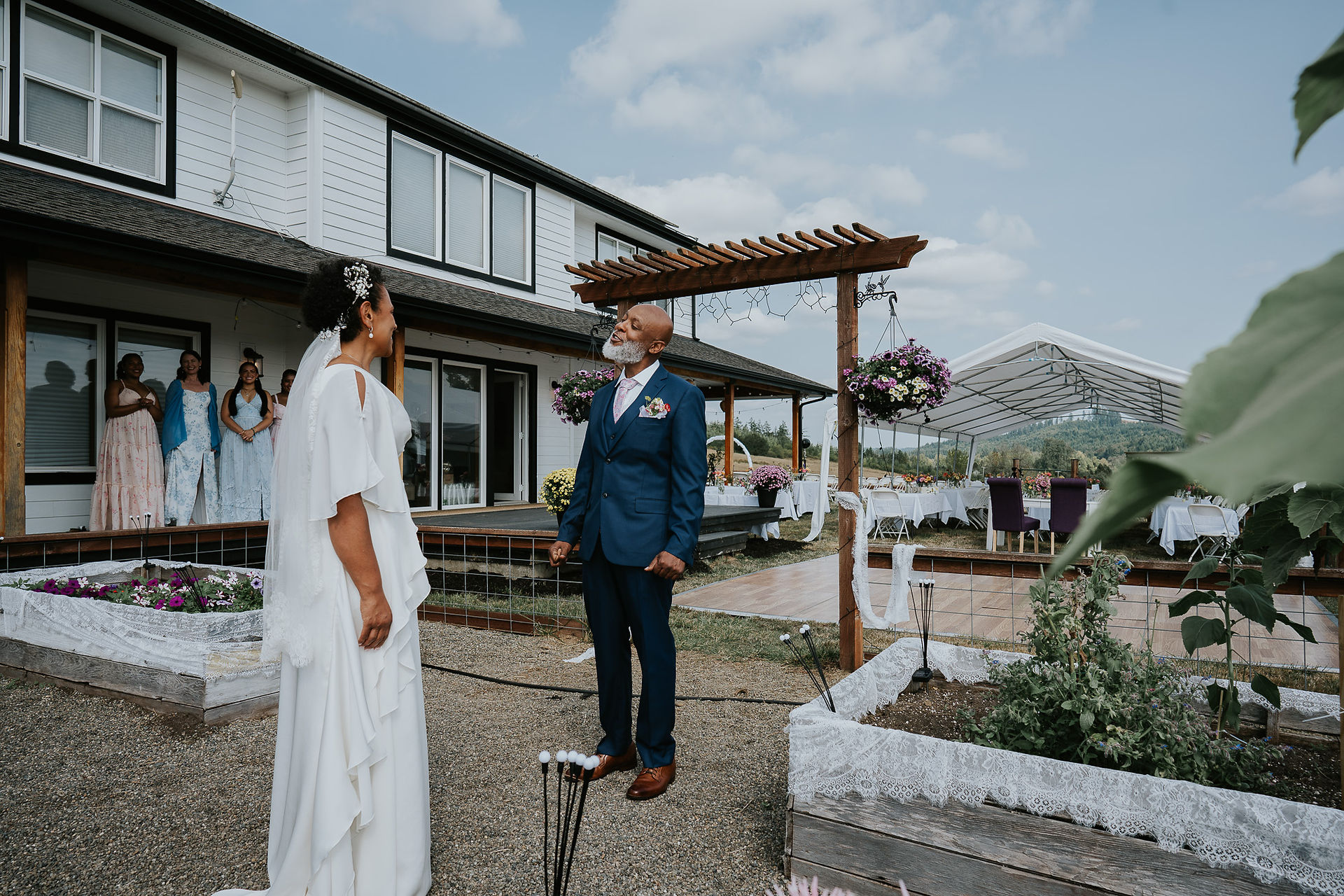 Bride looks at groom looking up at their intimate farm wedding.