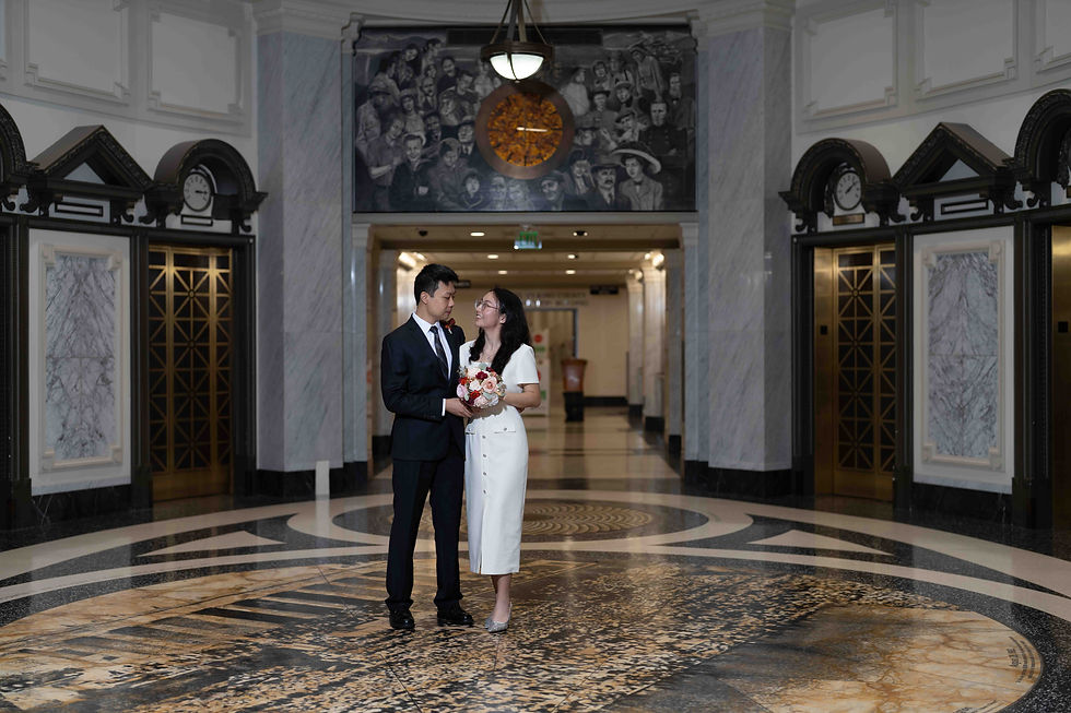 A happy couple in wedding attire crossing a street, embracing new beginnings outdoors.