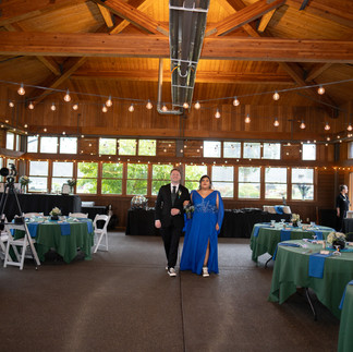 Man and woman walk aisle at Gold Mountain Golf Club wedding reception.