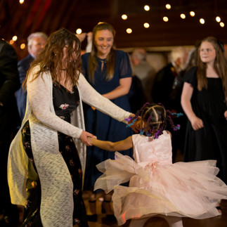 Woman and young girl dancing, twirling joyfully at a reception.