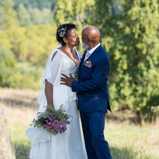 Loving Black couple kissing during their intimate farm wedding.