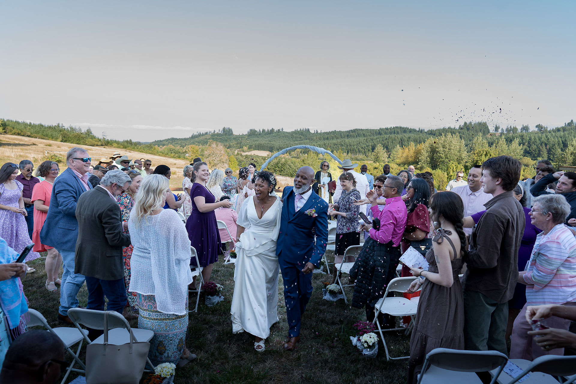Newlywed couple walking down aisle at an intimate outdoor farm wedding.