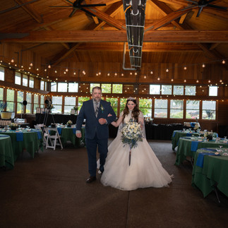 Bride and man enter rustic Gold Mountain Golf Club wedding venue