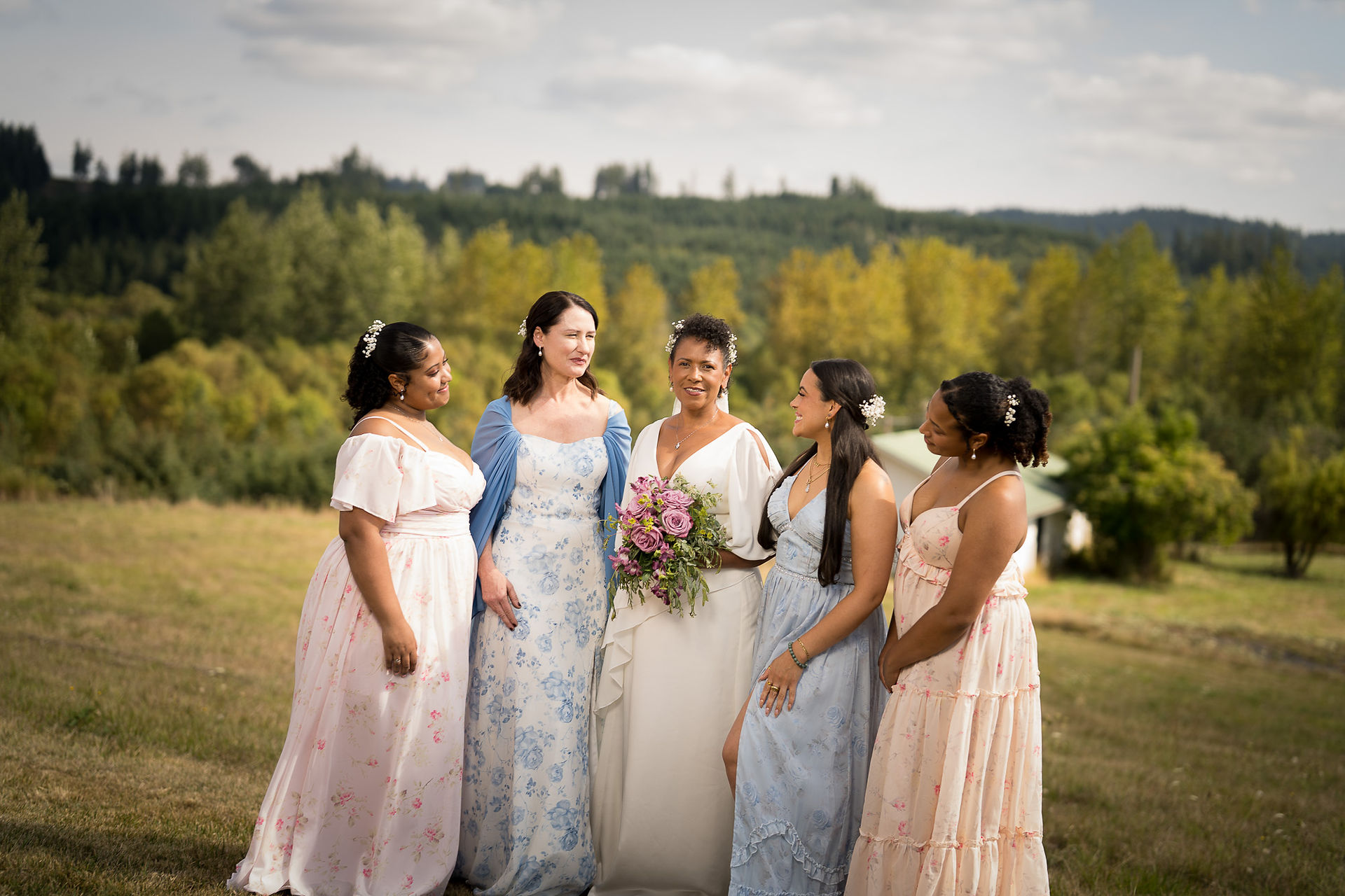 Bride and four bridesmaids smiling outdoors at an intimate farm wedding.