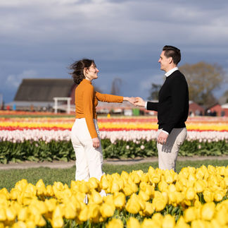 Couple holding hands in yellow tulips at Skagit Tulip Festival