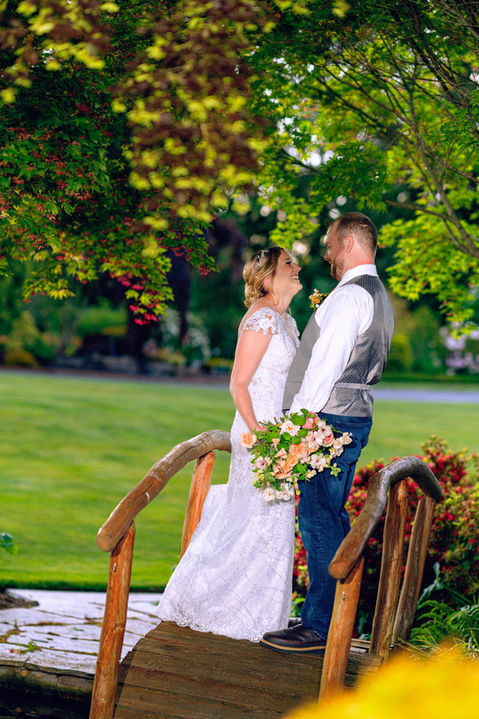 Happy couple on bridge, wedding flowers