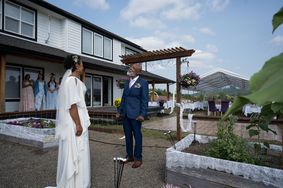 Bride and man in suit at intimate outdoor farm wedding.