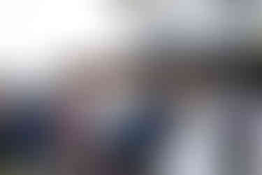 Smiling older bride and groom seated at an intimate farm wedding.