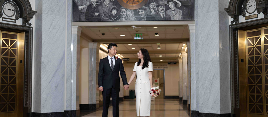 Bride and groom pose in the grand hallway of the Seattle Courthouse during their elegant city wedding, captured by PhotoYari Photography