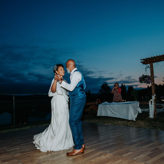Newlyweds first dance outdoors under the beautiful evening sky.