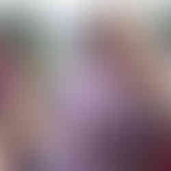 Smiling couple outdoors, man in cowboy hat, woman holding a drink.