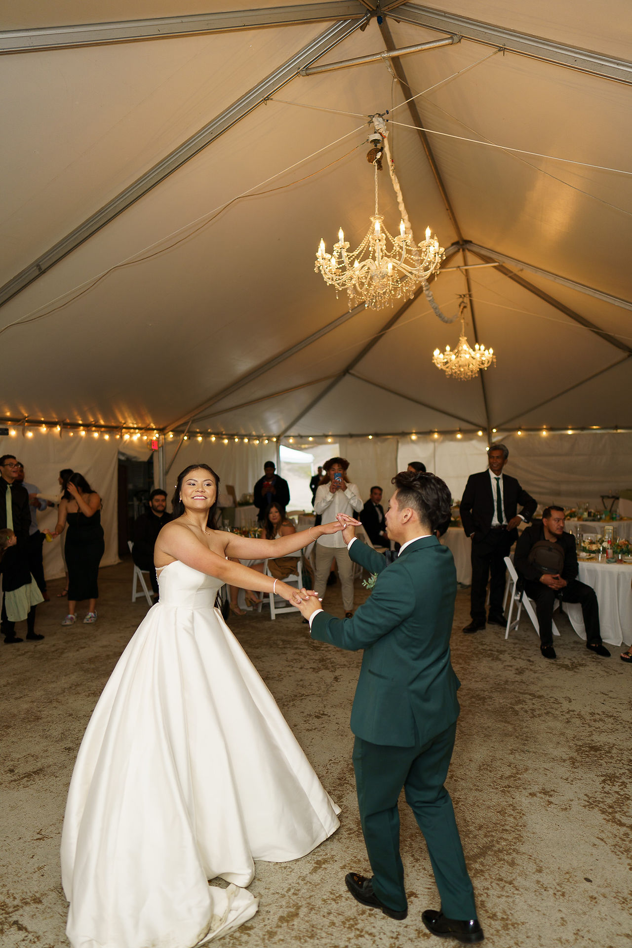 Bride and groom happily dancing under elegant wedding tent at Sanders Estate.