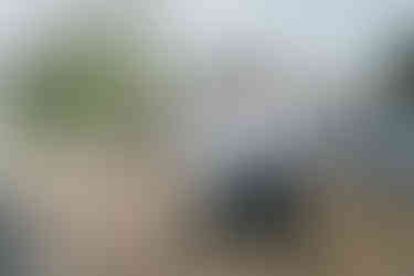 Two men, one in cowboy hat, one in suspenders, standing outdoors.