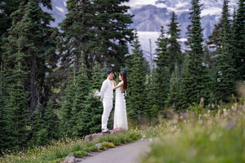 Couple in white attire gazing on mountain path. Elopement, PNW elopement photographer.
