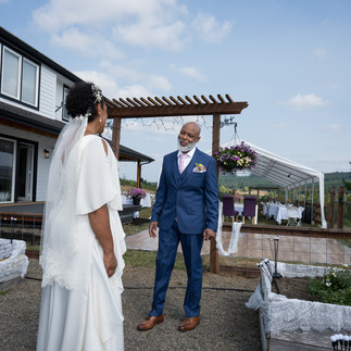 Bride and smiling man at outdoor farm wedding venue.