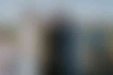 Bride and groom exchanging rings with officiant at outdoor farm wedding.