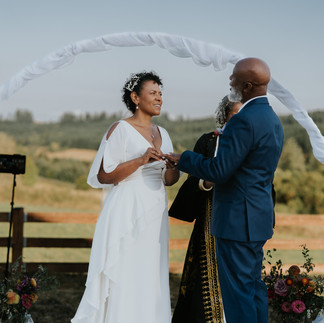 Bride and groom exchanging rings at their beautiful outdoor wedding ceremony.