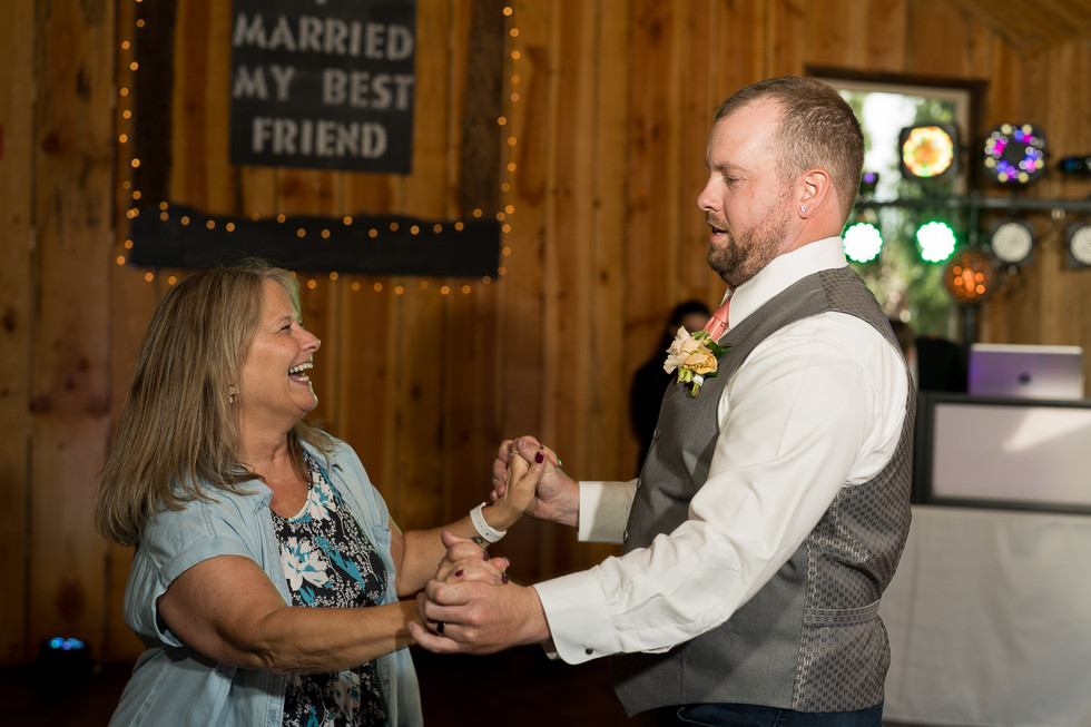 Man and woman dance at wedding reception, 'I MARRIED MY BEST FRIEND' sign.