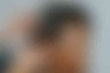 Woman having her curly hair styled with baby's breath accessory for wedding.