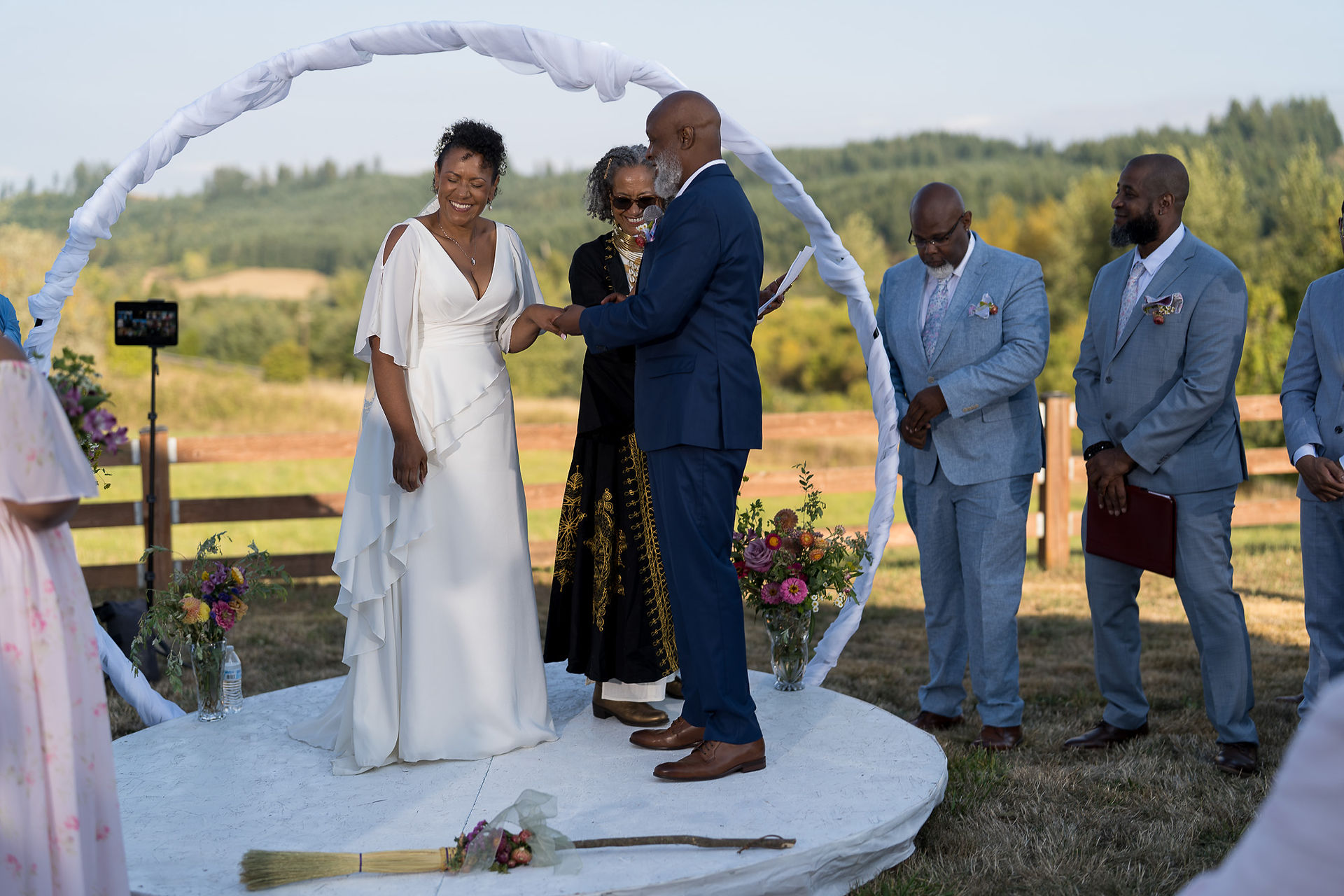 Bride and groom exchanging rings at an outdoor farm wedding ceremony.