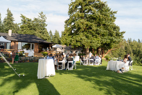 Outdoor wedding reception guests on a green lawn, Camano Island.