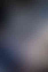 Smiling bride with bouquet escorted by man at outdoor wedding ceremony.