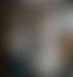 Young ring bearer giving gift to bride under a "Love" sign.