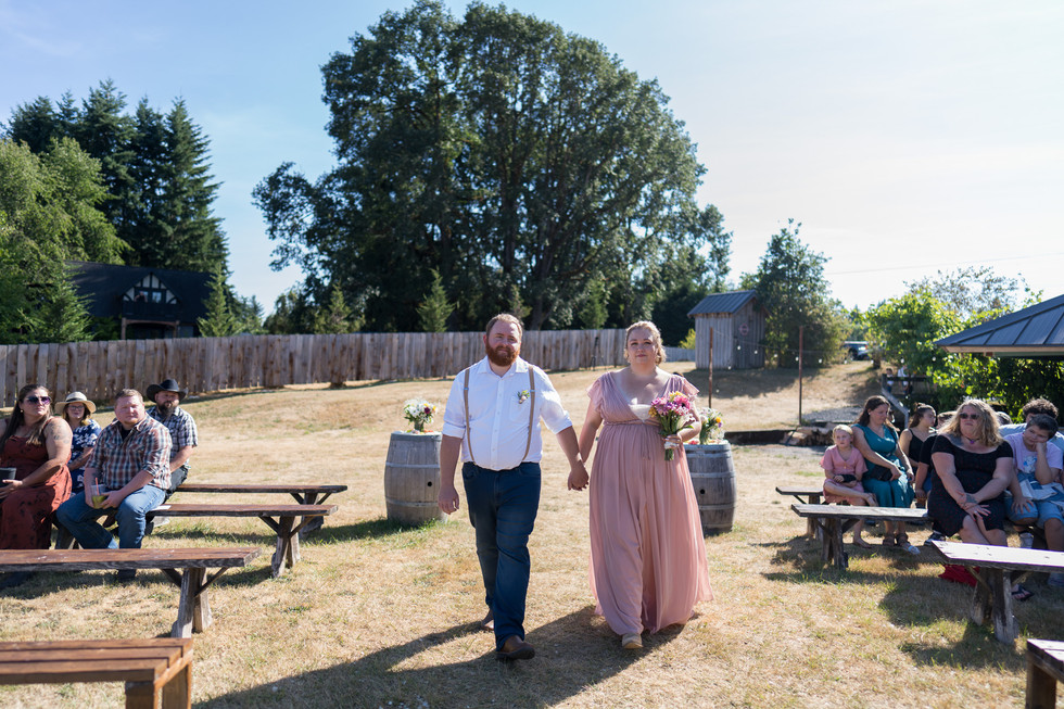 Happy couple walking at rustic Chehalis wedding at The Barn on Jackson.