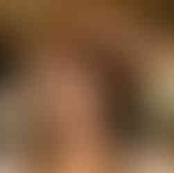 Smiling woman getting her hair styled by a professional hairdresser.