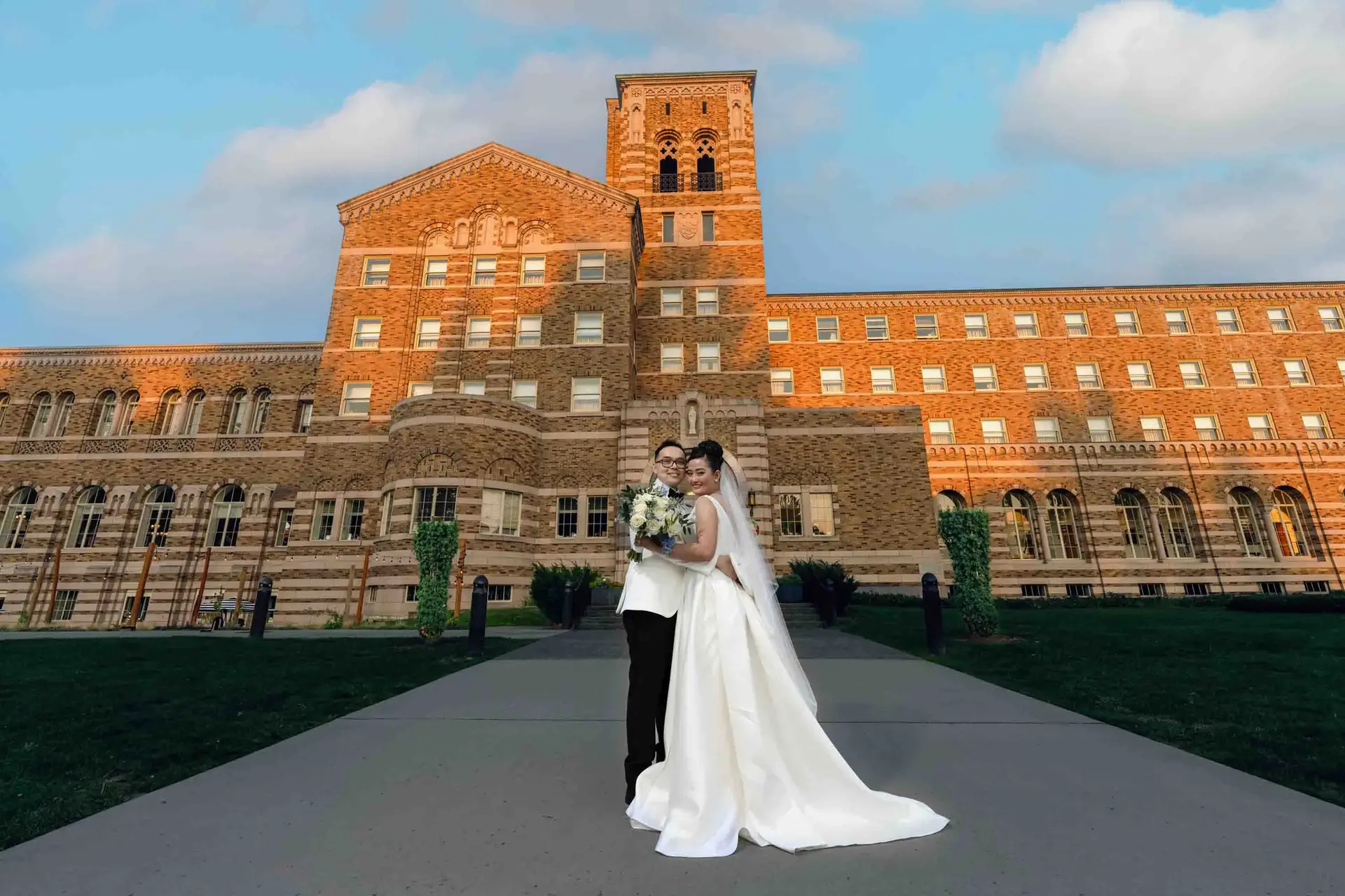 Happy couple poses for wedding photo in front of grand building