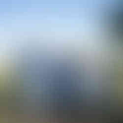 Five men in suits smiling and talking at an intimate farm wedding.