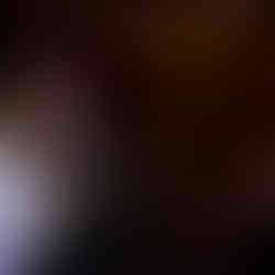 Man and woman dancing happily in festive reception hall with bokeh lights.