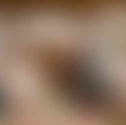 Groom gives speech, bride smiling at their decorated wedding reception table.