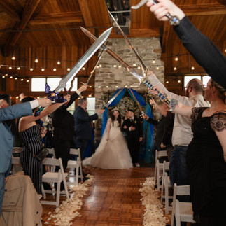 Bride walks under sword arch at Gold Mountain Golf Club wedding.