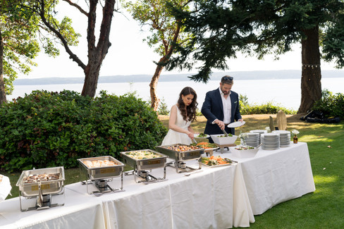 Intimate Backyard Wedding Bliss: couple serves buffet food on Camano Island, WA.