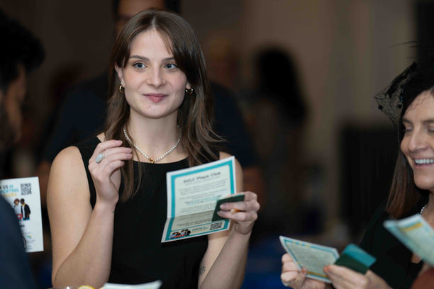 Woman smiling, holding event brochures