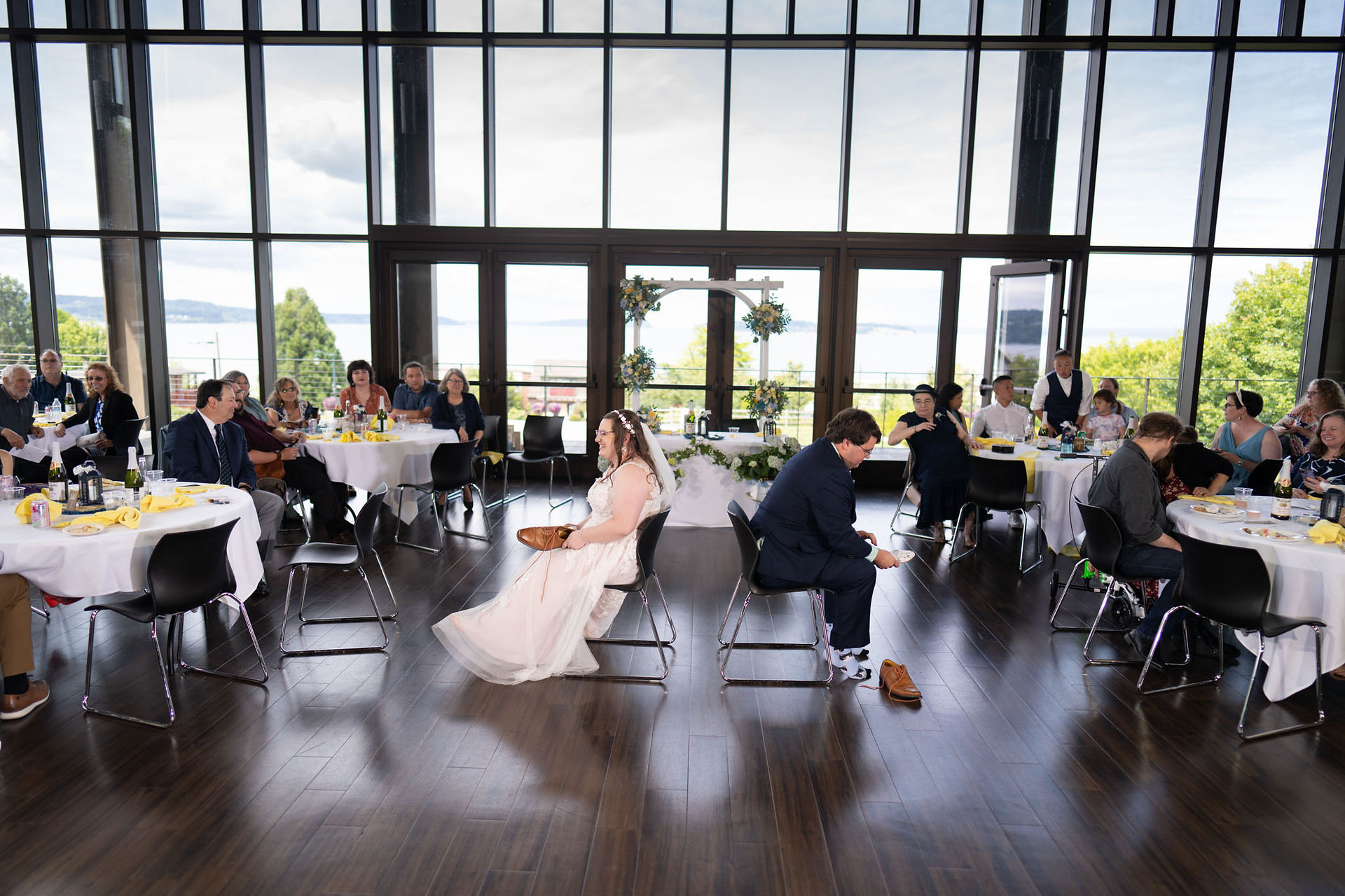 Bride and groom seated, wedding guests at tables