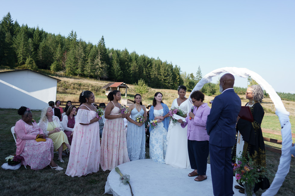 Bridal party and officiant at an outdoor farm wedding ceremony.