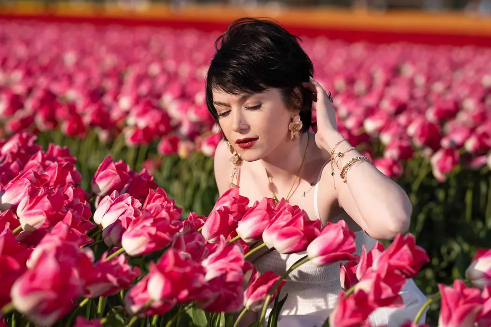 Close-up view of a bride holding a bouquet of tulips with blurred tulip fields in the background